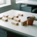 Onafgewerkt organigram van houten blokken op wit bureau, naast verwaarloosde plant met droge aarde, symboliseert vastgelopen organisatiestructuur.