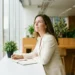 HR-professional denkt na aan een licht modern bureau met notitieboek en plant, warm ochtendlicht door grote ramen.