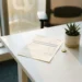 Loonstrook op wit bureau naast een kleine groene plant en gele munt, zacht natuurlijk licht in modern HR-kantoor.