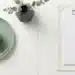 Groen appel en wit medisch klembord naast elkaar op wit oppervlak, symboliseren gezondheid en medische zorg.